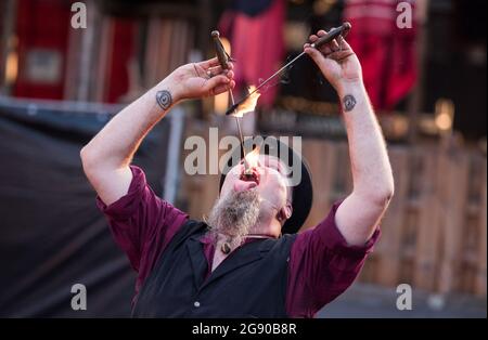 Hamburg, Deutschland. Juli 2021. Der Künstler Meister Eckart schluckt das Feuer während des Spielbuden Festivals auf dem Spielbudenplatz auf der Reeperbahn. Quelle: Daniel Bockwoldt/dpa/Alamy Live News Stockfoto