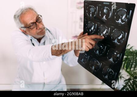 Leitender Arzt erklärt Röntgenaufnahmen im Krankenhaus Stockfoto