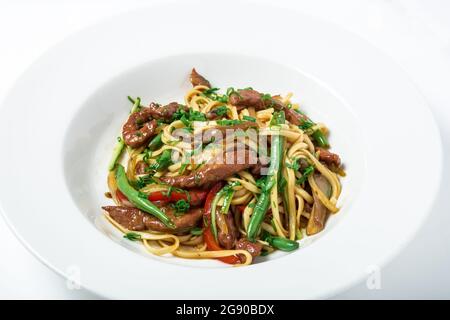 Thailändische Nudeln mit Straußenfleisch, grünen Bohnen und Pilzen. Stockfoto