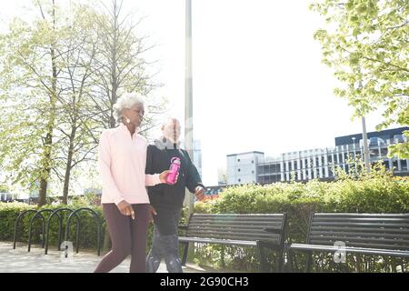 Ältere Frau, die mit dem Mann im Park läuft Stockfoto