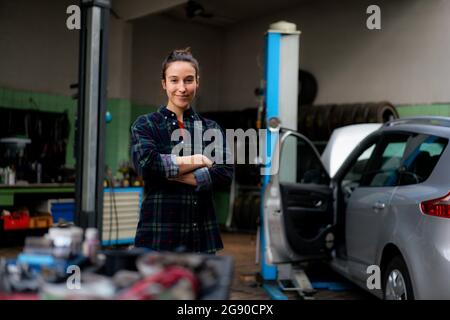 Selbstbewusste Mechanikerin, die in der Werkstatt steht Stockfoto