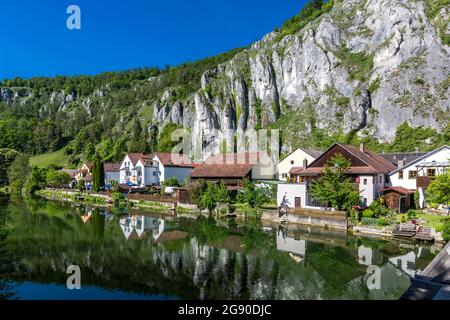 Deutschland, Bayern, Essing, Stadt am Ufer des Altmühls mit steilen Klippen im Hintergrund Stockfoto