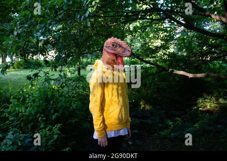 Vorpubertär Junge trägt Dinosaurier-Maske Stockfoto