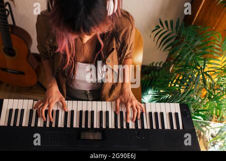 Junge Musikerin, die zu Hause Klavier spielt Stockfoto