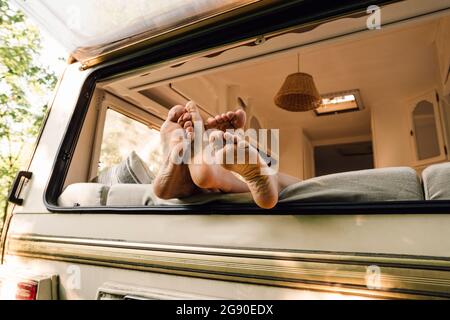 Die Füße des jungen Paares auf dem Wohnmotorenfenster Stockfoto