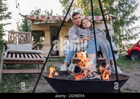 Junges Paar in Decke nahe der Feuerstelle eingewickelt Stockfoto