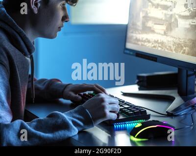 Junge spielen Online-Spiel auf dem Computer am Tisch Stockfoto