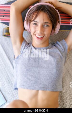 Schöne junge Frau mit Kopfhörern im Studio liegen Stockfoto