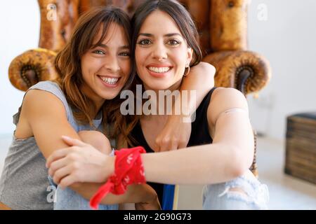 Glückliche Kolleginnen mit Arm im Kunststudio Stockfoto