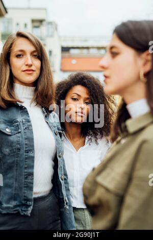 Selbstbewusste junge Freundinnen stehen zusammen Stockfoto