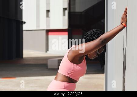 Müde kurvige junge Frau, die sich an der Wellwand lehnt Stockfoto