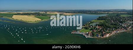 Bosham Village mit Booten, die in der Mündung in der wunderschönen Landschaft von West Sussex in Südengland festgemacht sind. Luftpanorama-Foto. Stockfoto