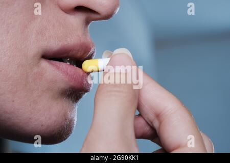 Eine Frau nimmt eine Kapsel Medizin. Konsum der Droge. Behandlung der Krankheit. Stockfoto