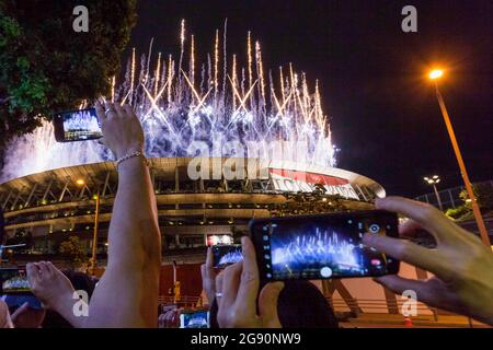 Tokio, Japan. Juli 2021. Unterstützer fotografieren das Feuerwerk mit ihren Smartphones im neuen Nationalstadion in Gaiemmae, Tokio. Die verspäteten Olympischen Spiele 2020 in Tokio wurden am Freitag, den 23. Juli eröffnet, obwohl die Zahl der Coronavirus-Infektionen zunach nahm, sodass es keine Zuschauer im Stadion gab, die die Eröffnungszeremonie verfolgen konnten. Kredit: SOPA Images Limited/Alamy Live Nachrichten Stockfoto