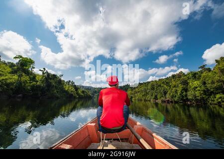 Mann, der den Tatai auf einem langen Boot in Kambodscha erkundet Stockfoto