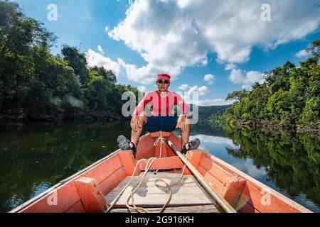 Mann, der den Tatai auf einem langen Boot in Kambodscha erkundet Stockfoto