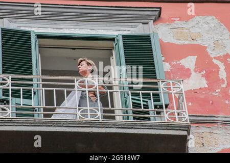 London, England, Großbritannien. Juli 2021. Eine Frau beobachtet den "Bees Against G20"-marsch vom Balkon ihres Hauses in Neapel, Italien. (Bild: © Sabrina MerollaZUMA Wire) Stockfoto