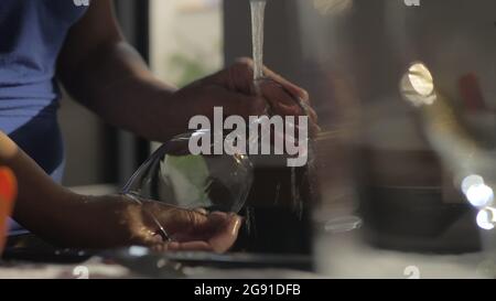 Frau, die in der Küche Weinglas wascht Stockfoto