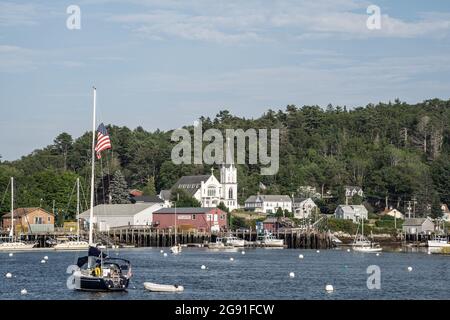 Boothbay, Maine, USA-12. Juli 2021: Katholische Kirche der Muttergottes des Friedens am Ufer des Boothbay Harbor, Maine. Hummer- und Fischerboote liegen im Harbo Stockfoto