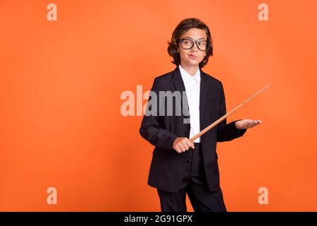 Foto von jungen gesinnten nachdenklichen Jungen suchen leeren Raum halten Stock isoliert auf glänzendem orangefarbenen Hintergrund Stockfoto