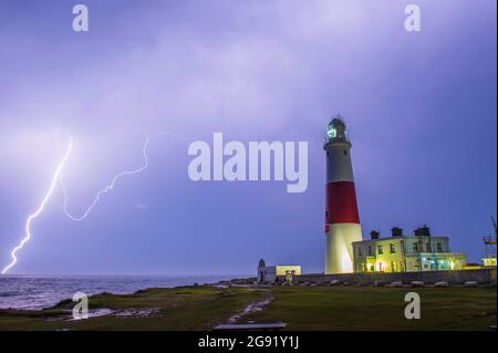 Weymouth, Dorset, Großbritannien. Juli 2021. Wetter in Großbritannien. Blitzstreifen am Himmel über dem Portland Bill Lighthouse in Dorset, während heftige Regenfälle und Gewitter über Nacht passieren, während die einwöchige Hitzewelle mit einem Knall endet. Bildnachweis: Graham Hunt/Alamy Live News Stockfoto