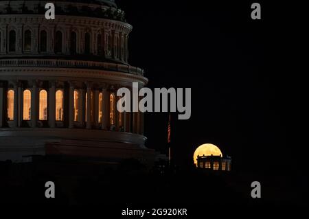 Washington, USA. Juli 2021. Der volle „Buck“-Mond steigt am Freitag, den 23. Juli 2021, hinter dem US-Kapitolgebäude in Washington, DC, Inmitten der Coronavirus-Pandemie. Diese Woche im Kongress scheiterte ein parteiübergreifendes Infrastrukturpaket an einer Testabstimmung im Senat, da Gesetzgeber und die Biden-Regierung vor der Augustpause eilig Fortschritte machen. (Graeme Sloan/Sipa USA) Quelle: SIPA USA/Alamy Live News Stockfoto