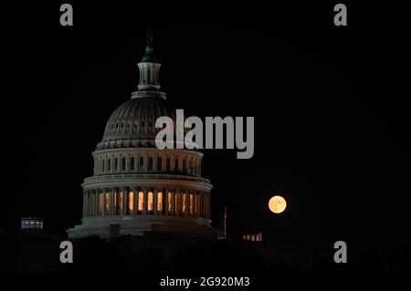 Washington, USA. Juli 2021. Der volle „Buck“-Mond steigt am Freitag, den 23. Juli 2021, hinter dem US-Kapitolgebäude in Washington, DC, Inmitten der Coronavirus-Pandemie. Diese Woche im Kongress scheiterte ein parteiübergreifendes Infrastrukturpaket an einer Testabstimmung im Senat, da Gesetzgeber und die Biden-Regierung vor der Augustpause eilig Fortschritte machen. (Graeme Sloan/Sipa USA) Quelle: SIPA USA/Alamy Live News Stockfoto