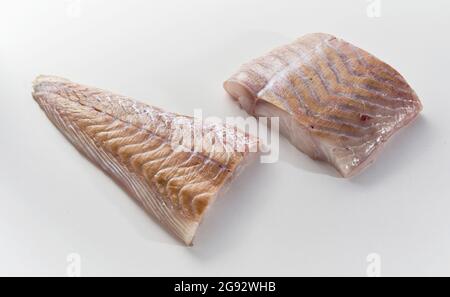 Von oben Tasse ungekochte Meerespollack Fischfilet auf weiße Oberfläche in der Küche platziert Stockfoto