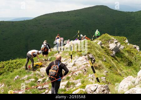 Wanderer, die mit einem Metallseil den Kozya Stena Peak oder die Chamois Wall auf dem Europäischen Übergangsweg E-3 durchqueren, Bulgarien, Balkan Stockfoto