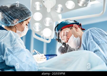 Konzentriert Op-Team den Betrieb eines Patienten in einem Operationssaal. Gut ausgebildete Anästhesisten mit Jahren Training mit komplexen Maschinen fol Stockfoto