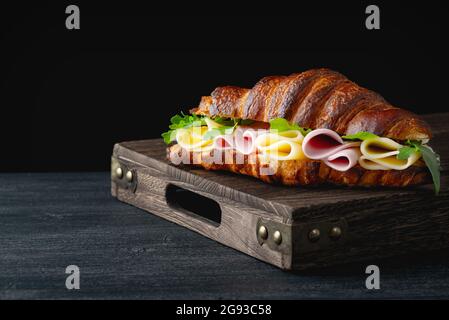 Croissant-Sandwich auf Holztisch Stockfoto