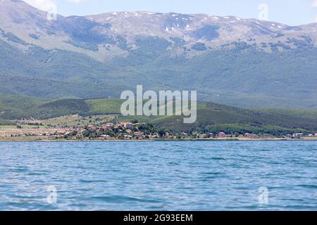 Blick auf den See Prespa am Dreipunkt Nordmazedonien, Albanien und Griechenland, kleines Dorf umgeben von Bergen, Albanien Stockfoto