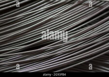 Edelstahldraht in der Produktionswerkstatt oder auf der Baustelle. Nahaufnahme von Drahtwalzen für die Federproduktion oder Betonbewehrung. Metall Stockfoto