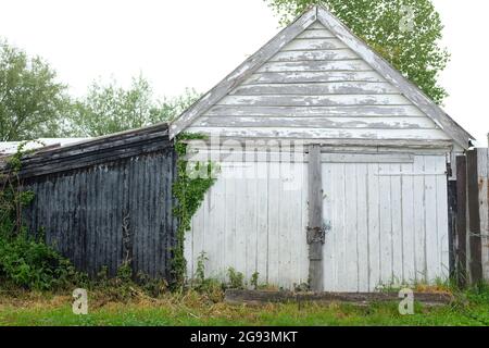 Juni 2021 - Alte weiße Holz Garagentore Stockfoto