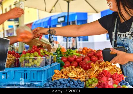 Frau, die Obst und Gemüse auf dem Bauernmarkt kauft. Nachhaltiger Lebensstil. Frische Bio-Produkte zum Verkauf auf dem lokalen Bauernmarkt. Stockfoto