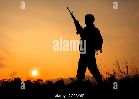 Silhouette Schuss von Soldat halten Waffe Stockfoto