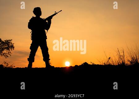 Silhouette Schuss von Soldat halten Waffe Stockfoto