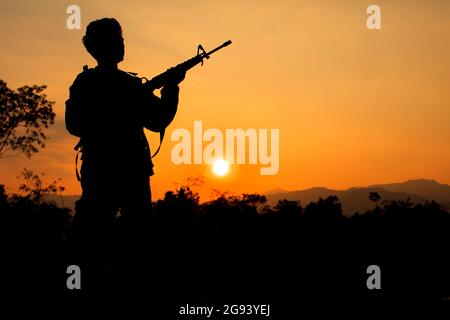 Silhouette Schuss von Soldat halten Waffe Stockfoto