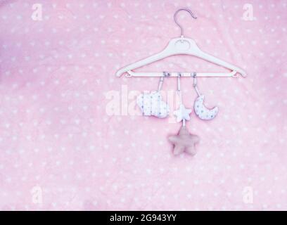 Mobile Babyspielzeug hängt auf einer rosa gepunkteten Decke Stockfoto