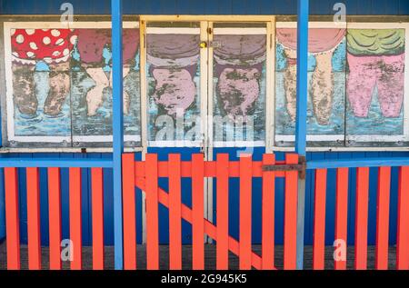 Landschaftsansicht einer Strandhütte, gemalt in Badekleidung, während man im Meer steht, Sutton-on-Sea, Lincolnshire, Großbritannien, Juni Stockfoto