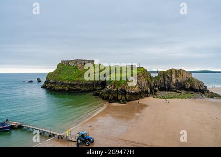 TENBY, WALES - 28. JUNI 2021: In Tenby im Südwesten von Wales schlendern die Menschen an einem Sandstrand entlang. Stockfoto