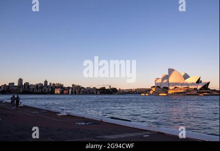 Sydney, Australien. Juli 2021. Die Menschen gehen auf einer leeren Straße in der Nähe des Opernhauses von Sydney, Australien, 24. Juli 2021. Da der Pandemieausbruch im australischen Bundesstaat New South Wales (NSW) weiter ansteigt, erklärten die staatlichen Behörden den Ausbruch am Freitag zu einem nationalen Notfall und forderten die Umleitung der nationalen Impfstofflieferungen. Quelle: Bai Xuefei/Xinhua/Alamy Live News Stockfoto