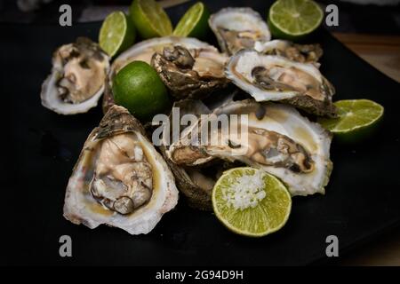 Offene Austern, zubereitet mit Zitrone und Salz Stockfoto