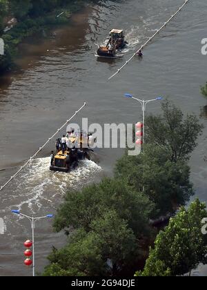 Zhengzhou, Chinas Provinz Henan. Juli 2021. Gestrandete Bewohner werden auf Schaufelladern in der überfluteten Stadt Weihui in der zentralchinesischen Provinz Henan evakuiert, 24. Juli 2021. Kredit: Li An/Xinhua/Alamy Live Nachrichten Stockfoto