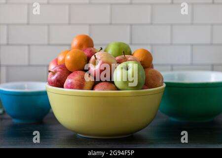 Äpfel und Orangen in der Vintage Fruit Bowl U-Bahn-Fliesenküche Stockfoto