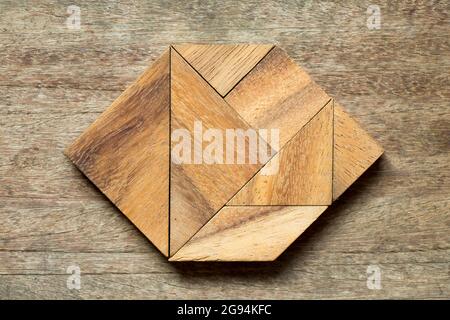 Tangram Puzzle in Sechseck-Form auf Holz-Hintergrund Stockfoto