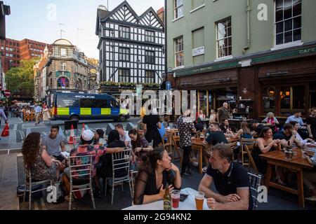 Menschen, die auf Tischen draußen auf der Old Compton Street, Soho, London, Großbritannien, trinken. Stockfoto