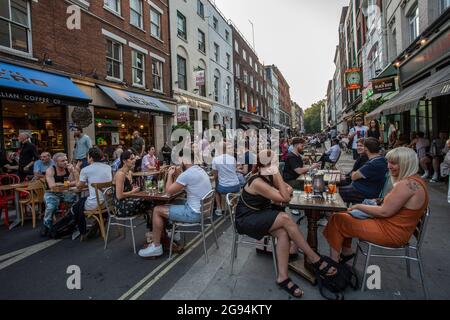 Menschen, die auf Tischen auf der Frith Street in Soho, London, am 23. Juli 2021, trinken Stockfoto