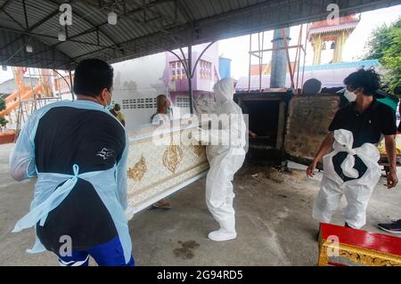 Nonthaburi, Thailand. Juli 2021. (ANMERKUNG DER REDAKTION: Bild zeigt den Tod) Tempelarbeiter tragen persönliche Schutzanzüge (PSA) und tragen während einer Trauerfeier im Wat Bang Muang in der Provinz Nonthaburi, am Stadtrand von Bangkok, einen Sarg eines COVID-19-Opfers zu einem Krematorium. Thailand hat bisher 481,967 Coronavirus-Fälle mit 327,789 Genesten und 3,930 Todesfällen bestätigt. (Foto von Chaiwat Subprasom/SOPA Images/Sipa USA) Quelle: SIPA USA/Alamy Live News Stockfoto