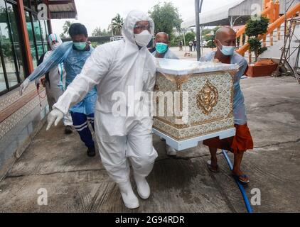 Nonthaburi, Thailand. Juli 2021. (ANMERKUNG DER REDAKTION: Bild zeigt den Tod) Tempelarbeiter tragen persönliche Schutzanzüge (PSA) und tragen während einer Trauerfeier im Wat Bang Muang in der Provinz Nonthaburi, am Stadtrand von Bangkok, einen Sarg eines COVID-19-Opfers zu einem Krematorium. Thailand hat bisher 481,967 Coronavirus-Fälle mit 327,789 Genesten und 3,930 Todesfällen bestätigt. (Foto von Chaiwat Subprasom/SOPA Images/Sipa USA) Quelle: SIPA USA/Alamy Live News Stockfoto